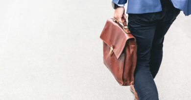 person walking holding brown leather bag