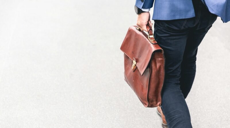 person walking holding brown leather bag