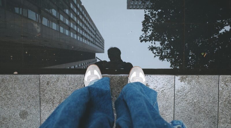 Person reflected in water with buildings, adding an urban touch.