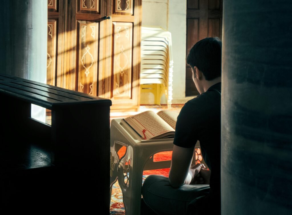 Adult reading Quran in a sunlit İstanbul mosque corner, symbolizing peace and meditation.